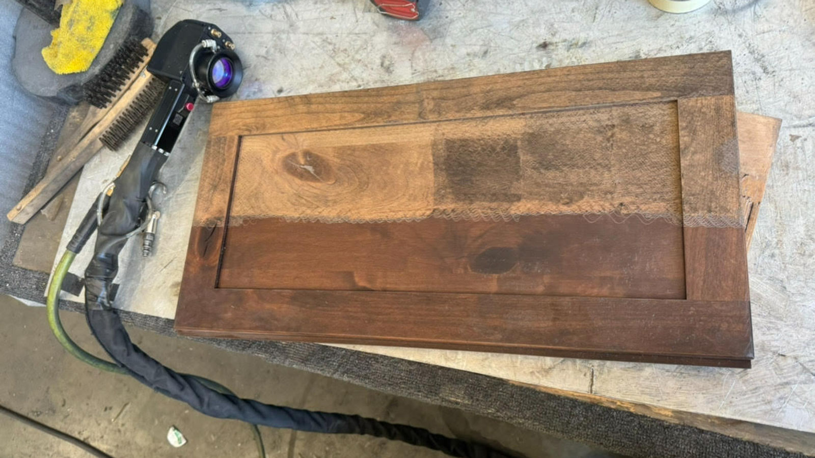 Kevin Vanderstar demonstrating laser cleaning on a wooden surface at the Oregon City workshop